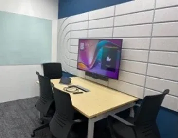 Huddle room with a wall display, video bar and table touch panel, installed by VisionCast