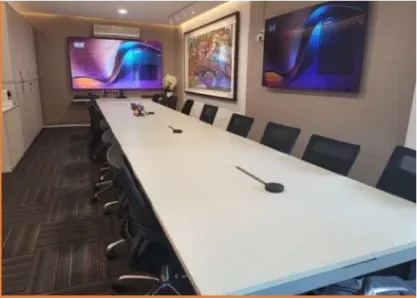 Long boardroom table with two wall displays and table microphones, installed by VisionCast