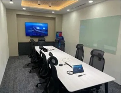 Mid-size meeting room with a wall display, video bar and table touch console, installed by VisionCast