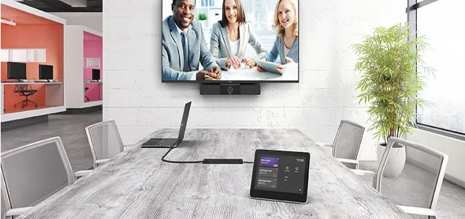 Office meeting space with a wall display and a table touch controller