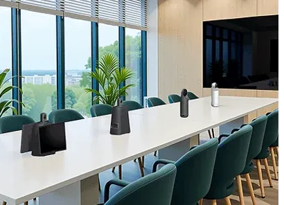 Large boardroom with a long white table and conferencing microphones