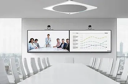 Long conference table with dual displays and a ceiling microphone